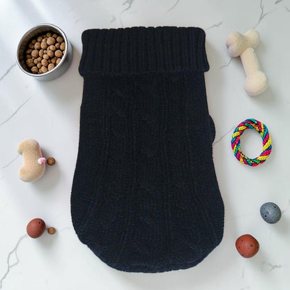 Furvana black knit pet sweater with a turtleneck design, laid flat on a white surface with dog toys and food bowl.
