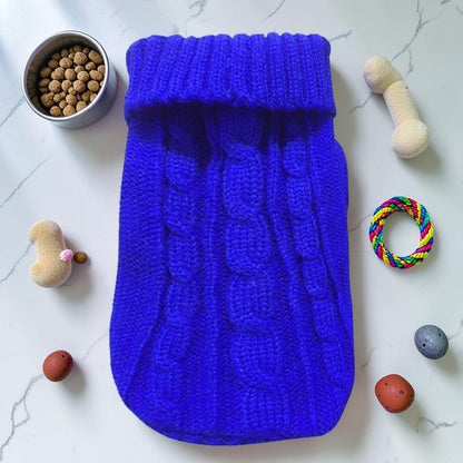 Furvana blue cable knit pet sweater with a turtleneck design laid flat on a white marble surface with toys