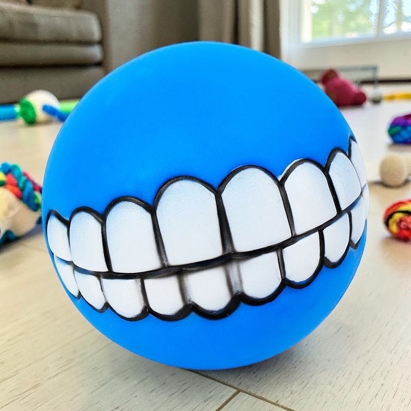 Furvana blue squeaky rubber dog ball toy featuring a funny human-like toothy grin design for interactive fetch play