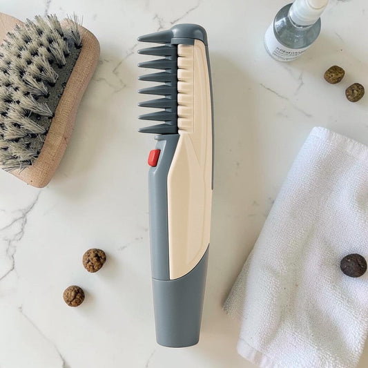 Furvana electric pet grooming comb with grey and beige ABS plastic body, rounded safety teeth, and red activation button.