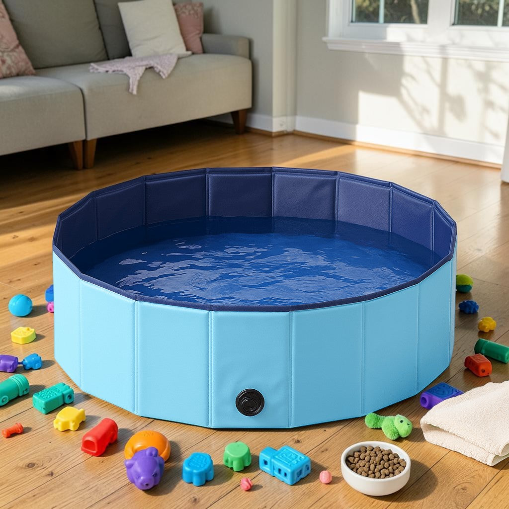 Furvana foldable pet swimming pool in light and dark blue PVC with a drain plug, set up on a wooden floor with toys.