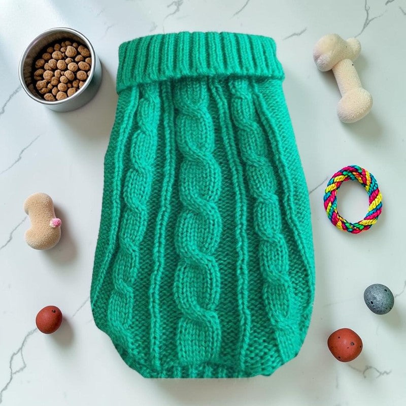 Furvana green cable knit pet sweater with a turtleneck, displayed flat with dog toys and food on a white surface.