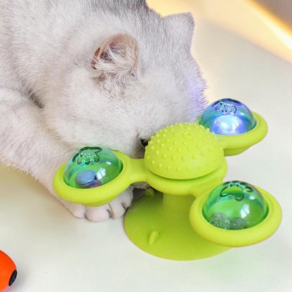 Furvana green windmill cat toy with suction base and interactive spinning compartments being played with by a cat
