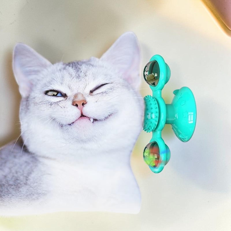 Furvana green windmill cat toy with suction base and interactive spinning compartments next to a happy cat