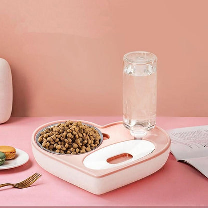 Furvana 2-in-1 heart-shaped pet feeder with a stainless steel food bowl and automatic water dispenser in soft pink.