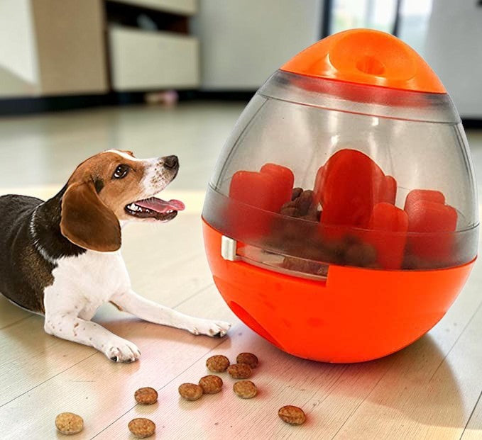 Furvana interactive orange treat ball toy with kibble for a beagle dog on a wooden floor