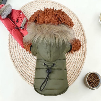 Furvana olive green hooded winter dog coat with faux fur trim on a small brown dog, seen from above.