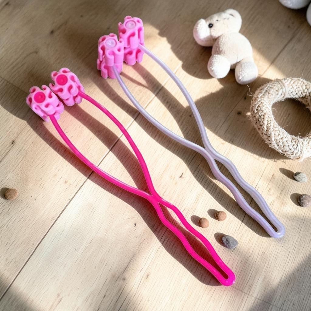Furvana pet face roller massagers in pink and white with ergonomic handles for gentle grooming on a wooden floor