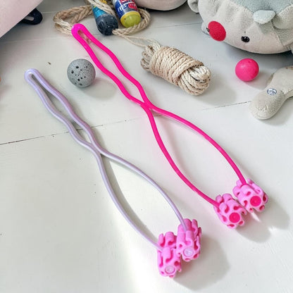 Furvana pet face roller massagers in pink and light purple with ergonomic handles for cats and dogs