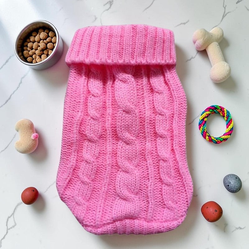 Furvana pink cable knit pet sweater with a turtleneck, laid flat on a white surface with toys and treats.