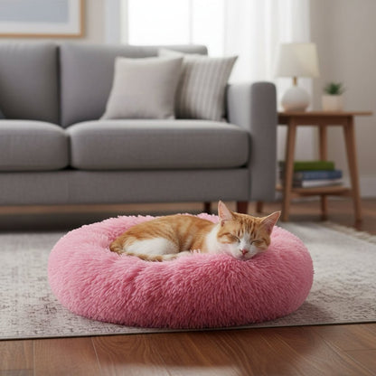 Furvana pink plush donut bed with a sleeping cat in a cozy living room setting
