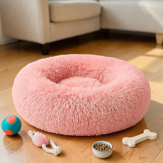 Furvana pink plush donut dog and cat bed with raised rim for comfort on a wooden floor with pet toys