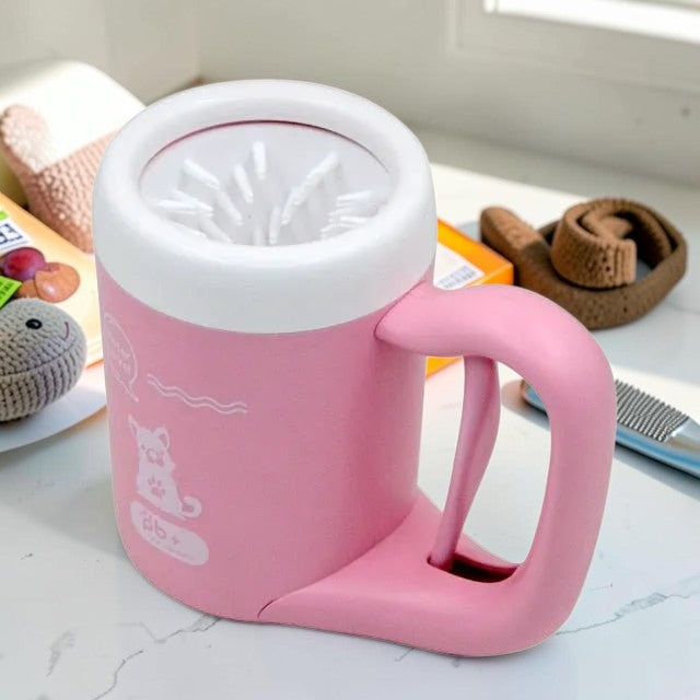 Furvana portable dog paw cleaner cup in pink with white silicone bristles and a convenient handle for easy cleaning.