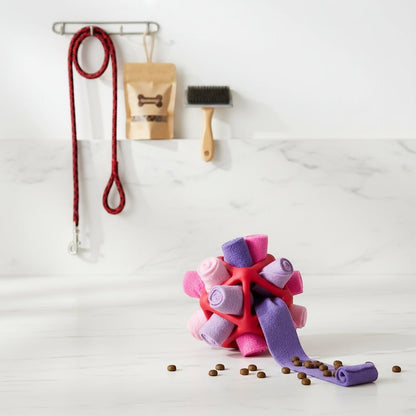 Furvana interactive snuffle ball dog toy in fantasy purple with soft fleece strips for hiding treats on a white surface.
