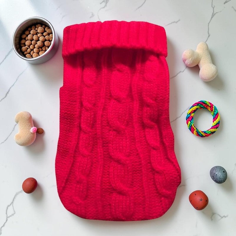 Furvana red cable knit pet sweater with a turtleneck design, laid flat on a white surface with toys and treats.