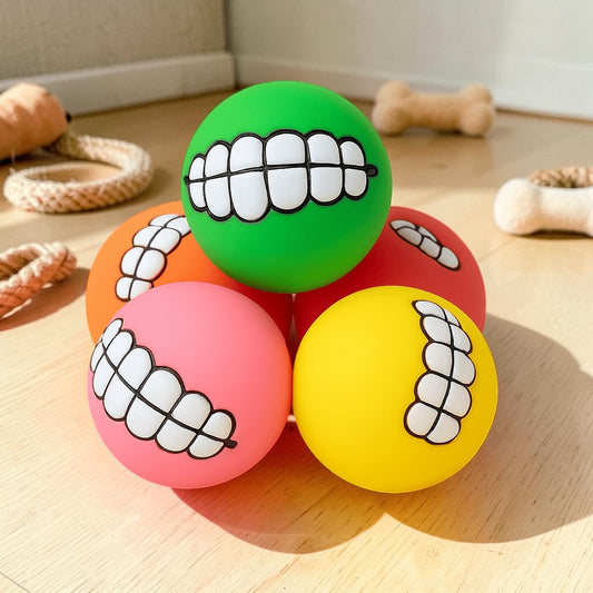 Furvana squeaky rubber dog balls in assorted bright colors with funny printed teeth designs for interactive play.