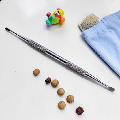 Furvana double-ended stainless steel dental scaler tool for pet teeth cleaning with small treats on a white surface