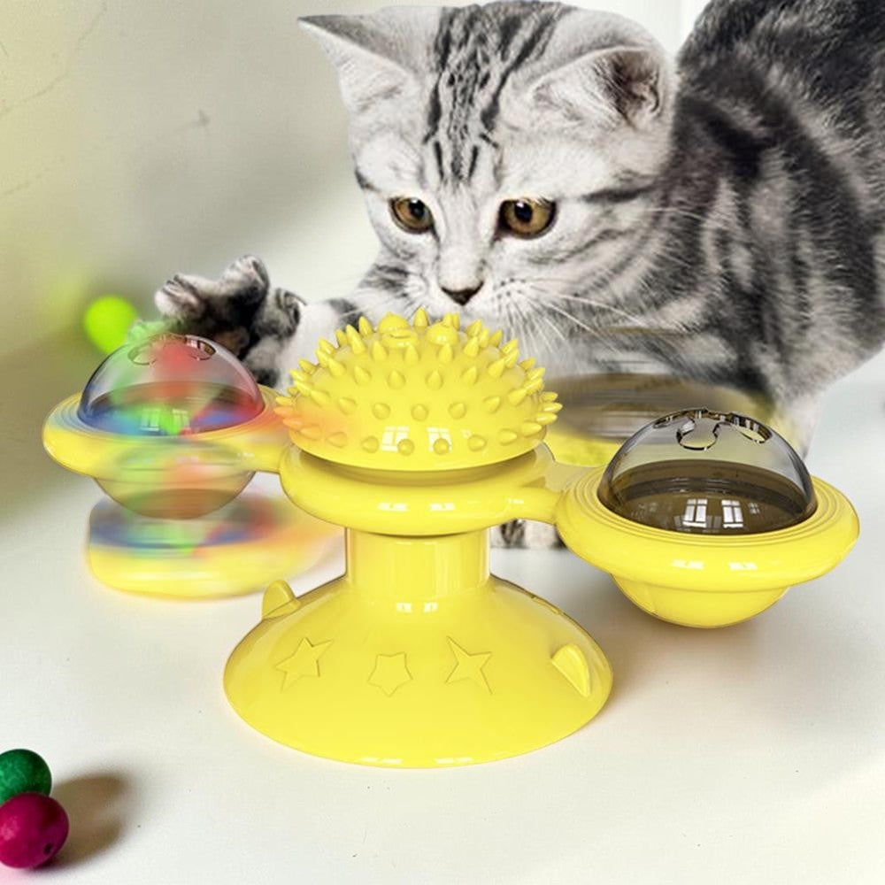 Furvana yellow windmill cat toy with suction base and spinning interactive compartments being played with by a kitten