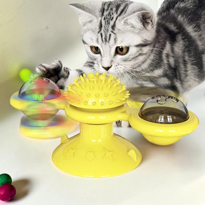 Furvana yellow windmill cat toy with suction base and spinning interactive compartments being played with by a kitten